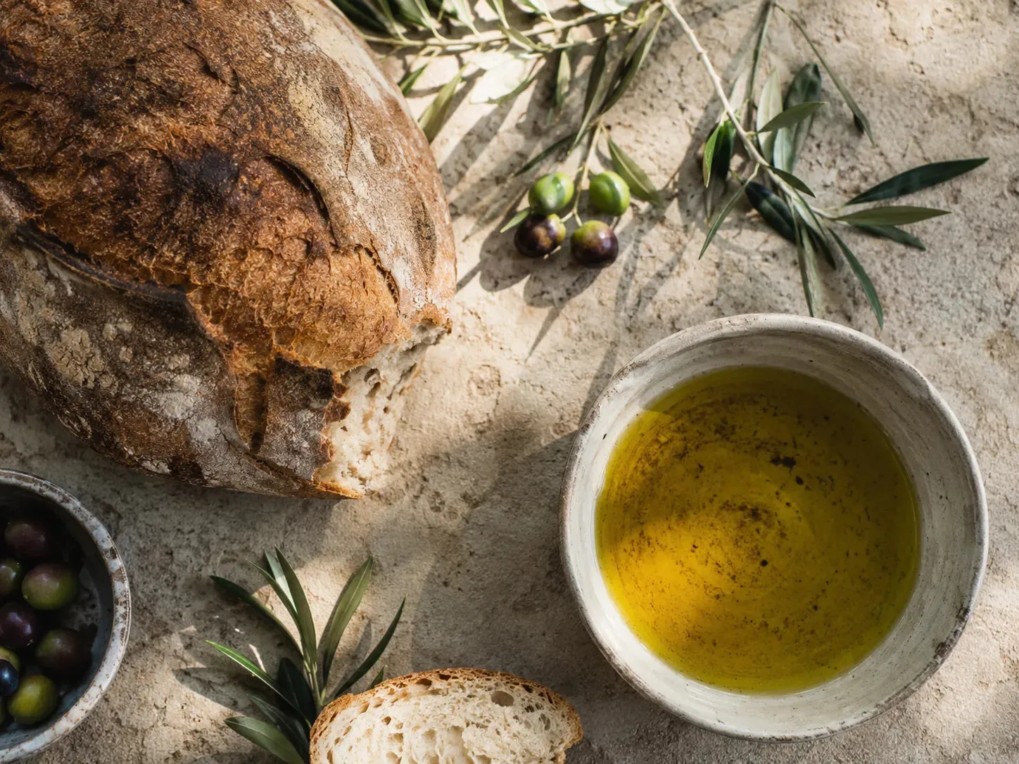 Bread, olives and olive oil on a table